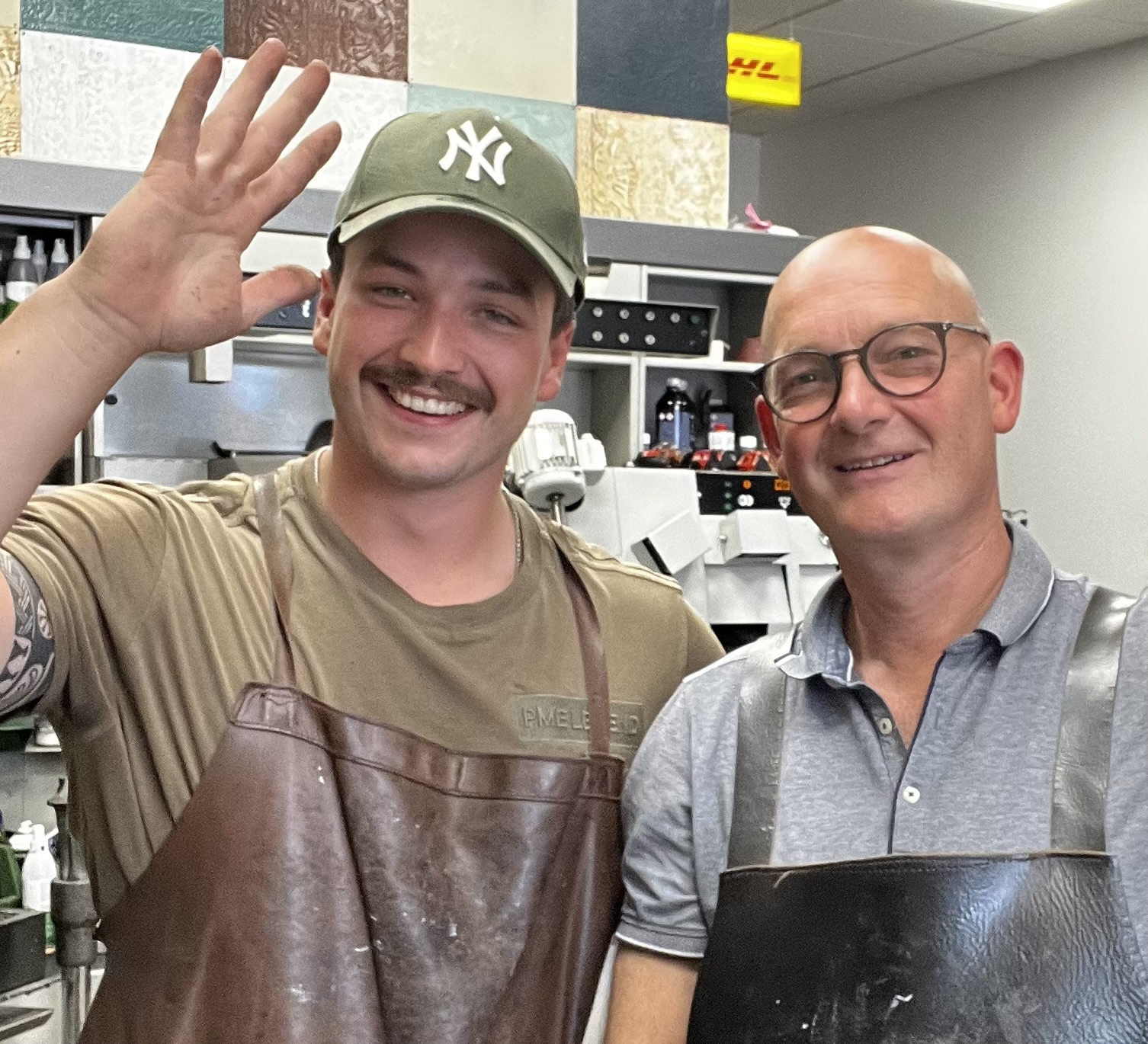 Twee vakmannen in leren schorten bij de finish-machine